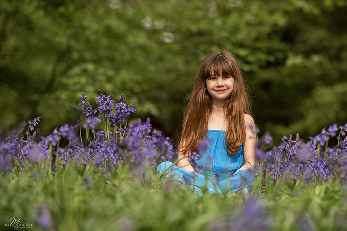 Girl sitting in bluebells